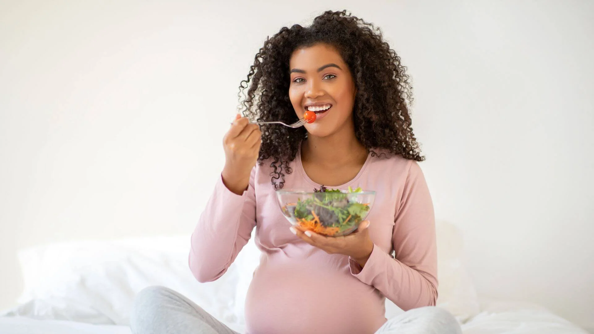 pregnant woman happily eating healthy food