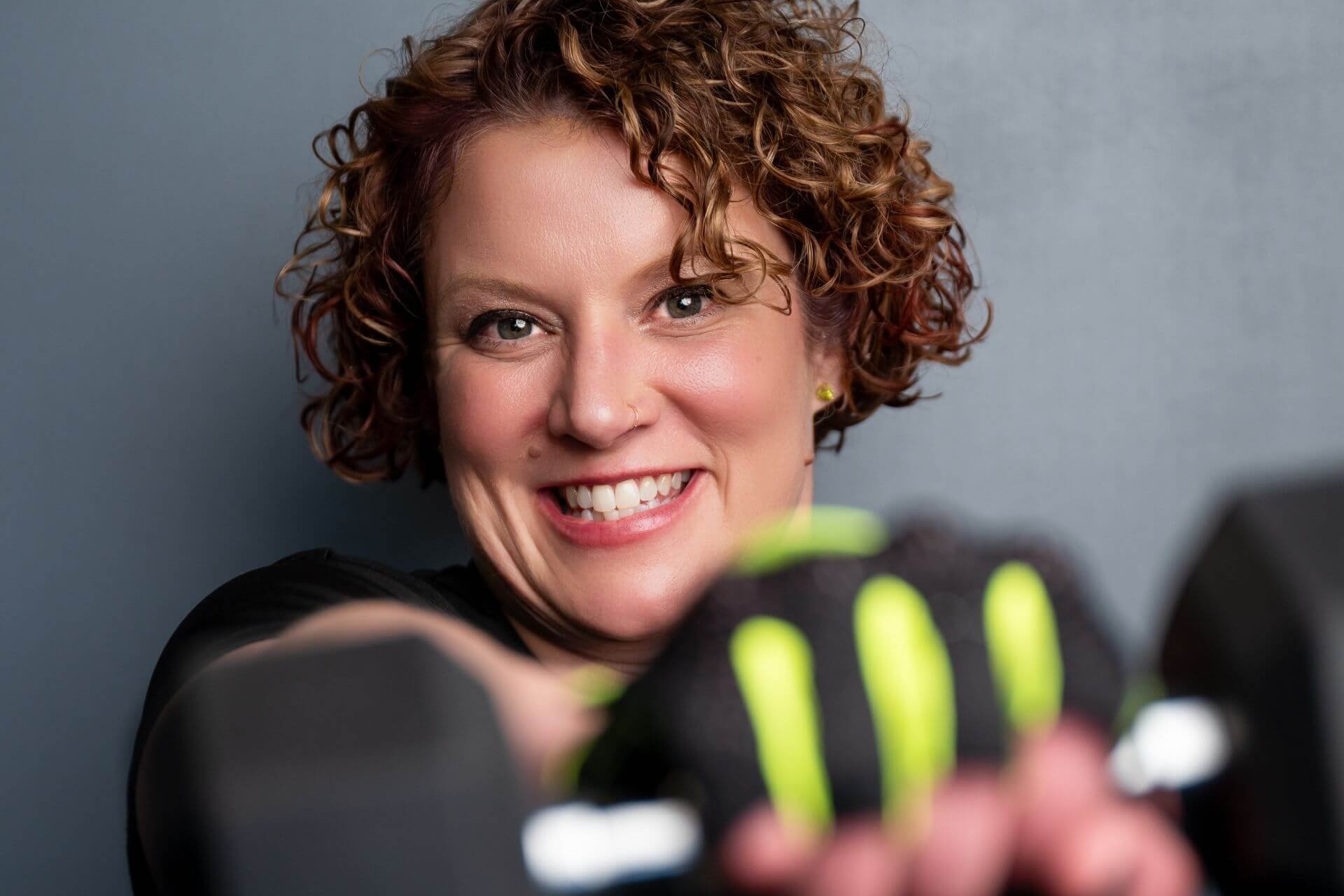 Lissa, owner of Peak Women, punching a weight in her women only gym in troy michigan