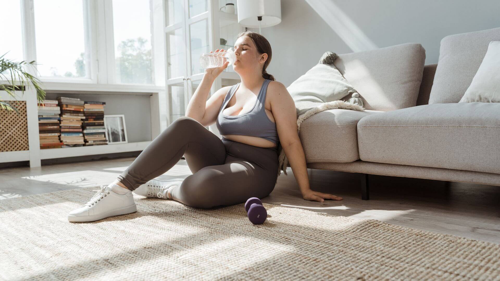 woman drinking water while exercising