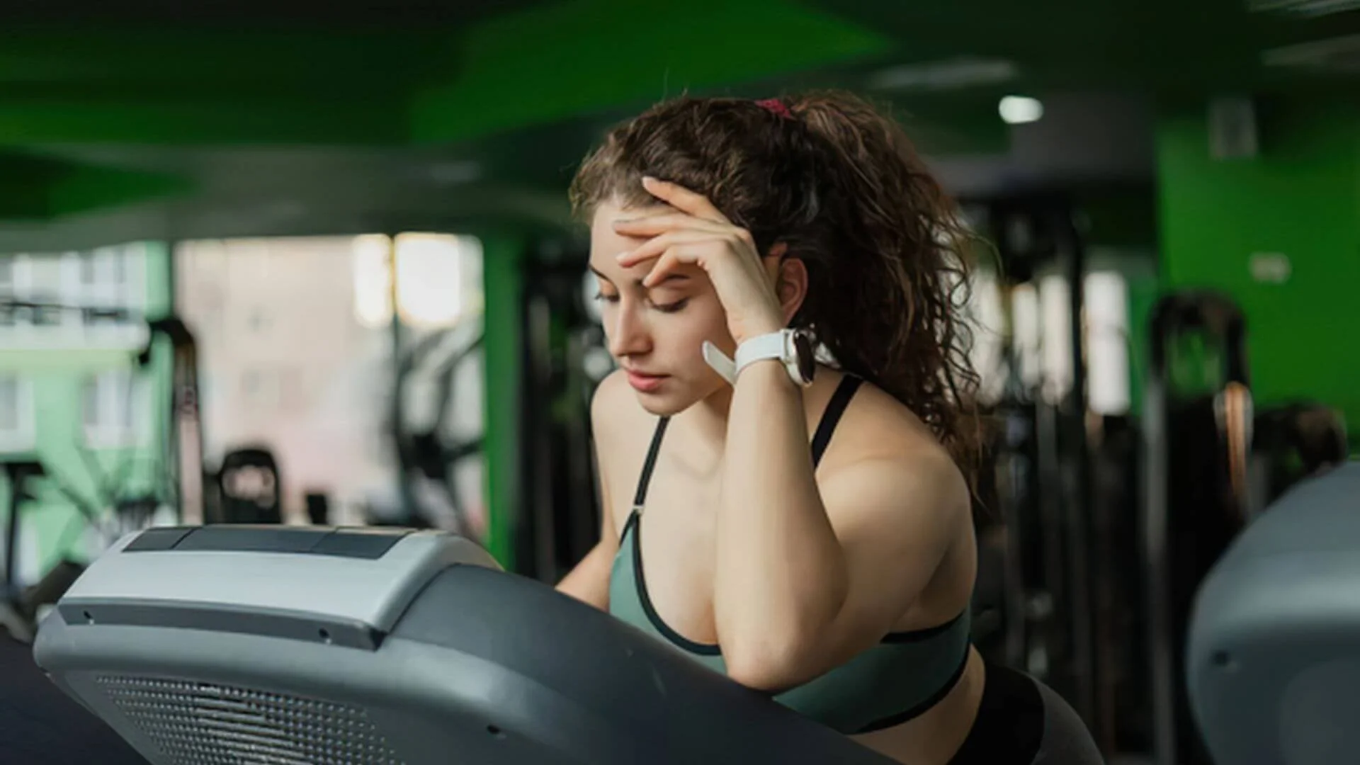 a woman on a treadmill looking not too happy about having to exercise