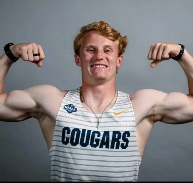 A young athlete wearing a white and gray striped sports jersey with 'COUGARS' written on front, flexing his biceps, and smiling.