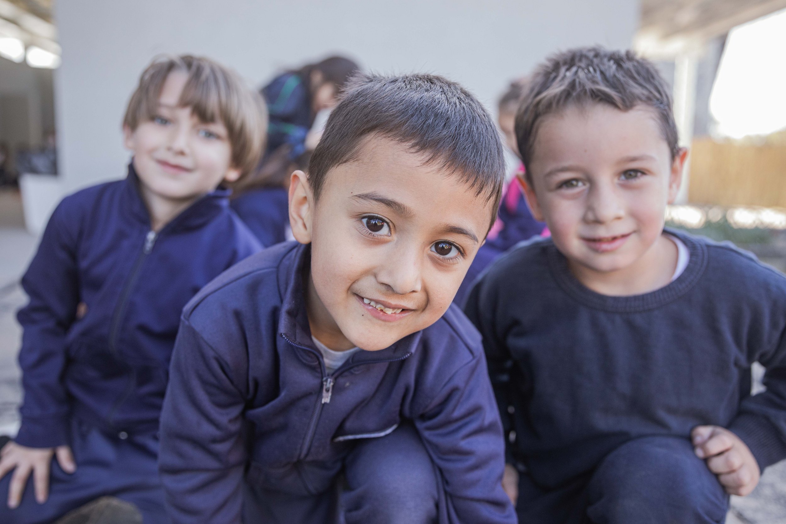Group of young children outdoors, smiling, and looking at the camera.