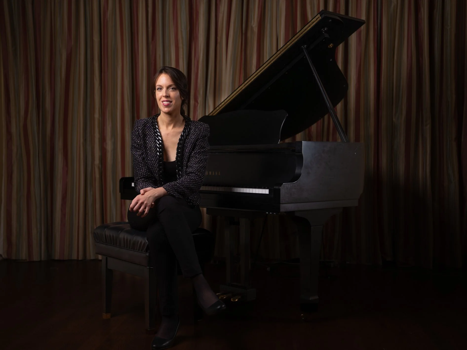 Dr. Julia Aguayo seated at a grand piano