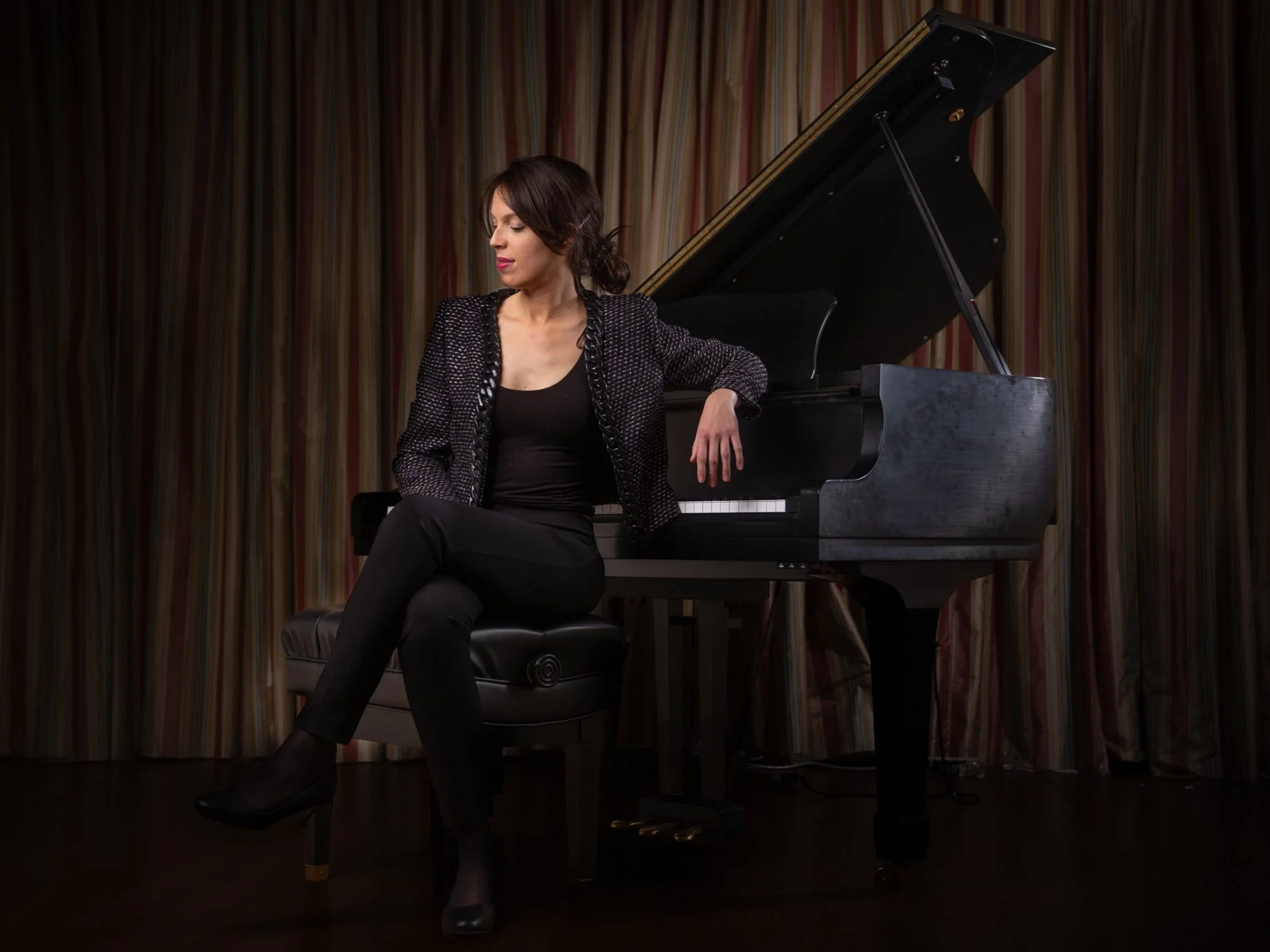 Pianist Dr. Julia Aguayo beside a grand piano