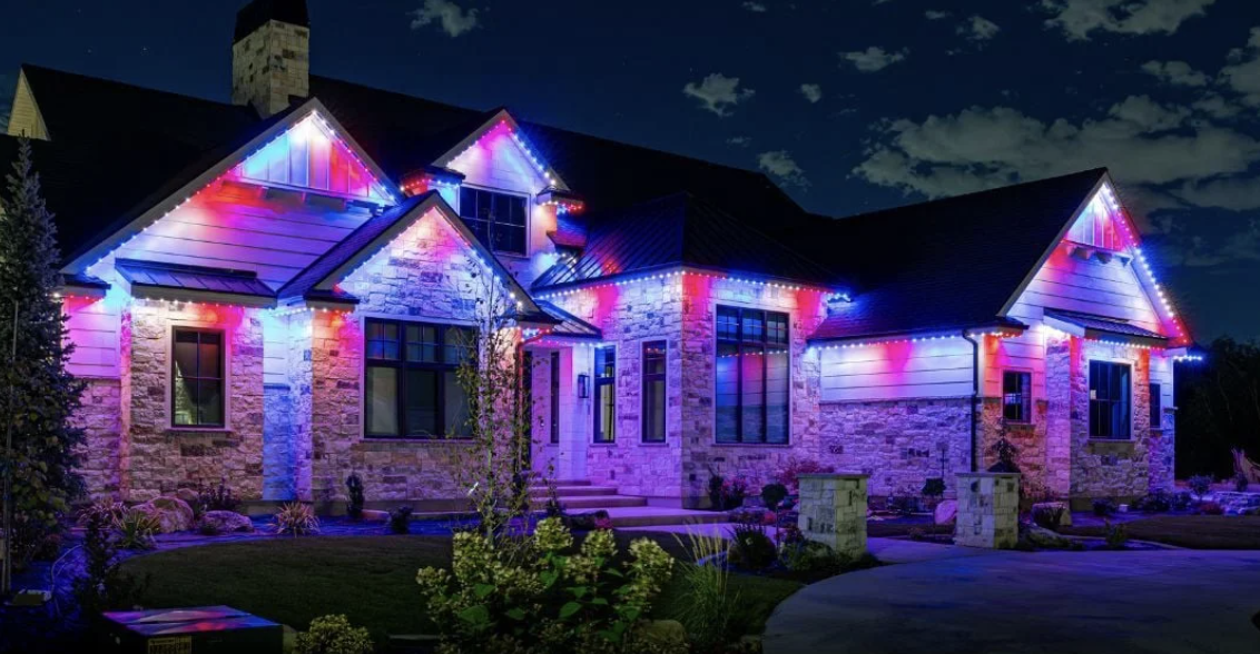 A house decorated with colorful Christmas or holiday string lights at night.