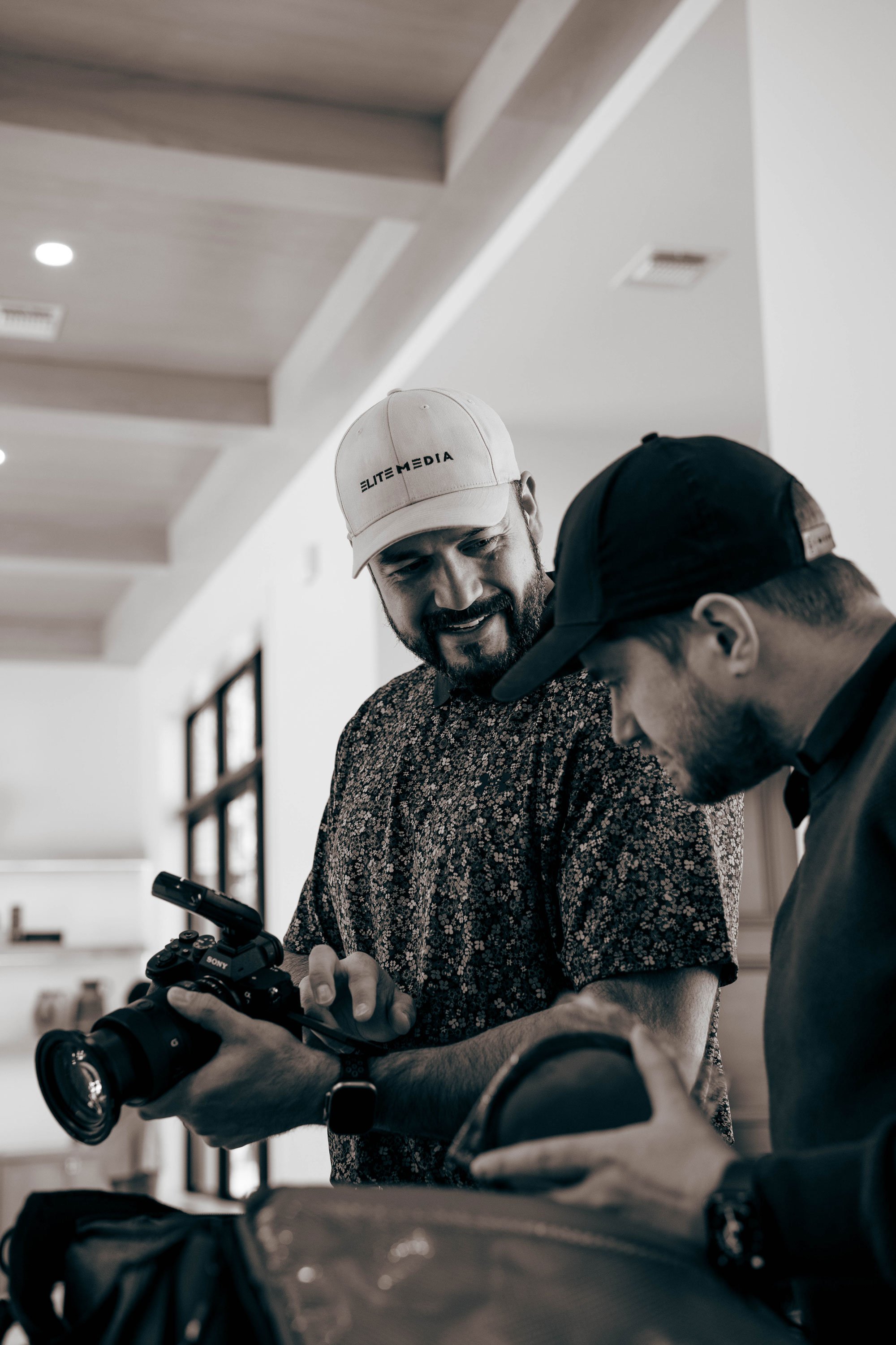 Founder of Elite Media and staff member discussing camera setting while on a shoot