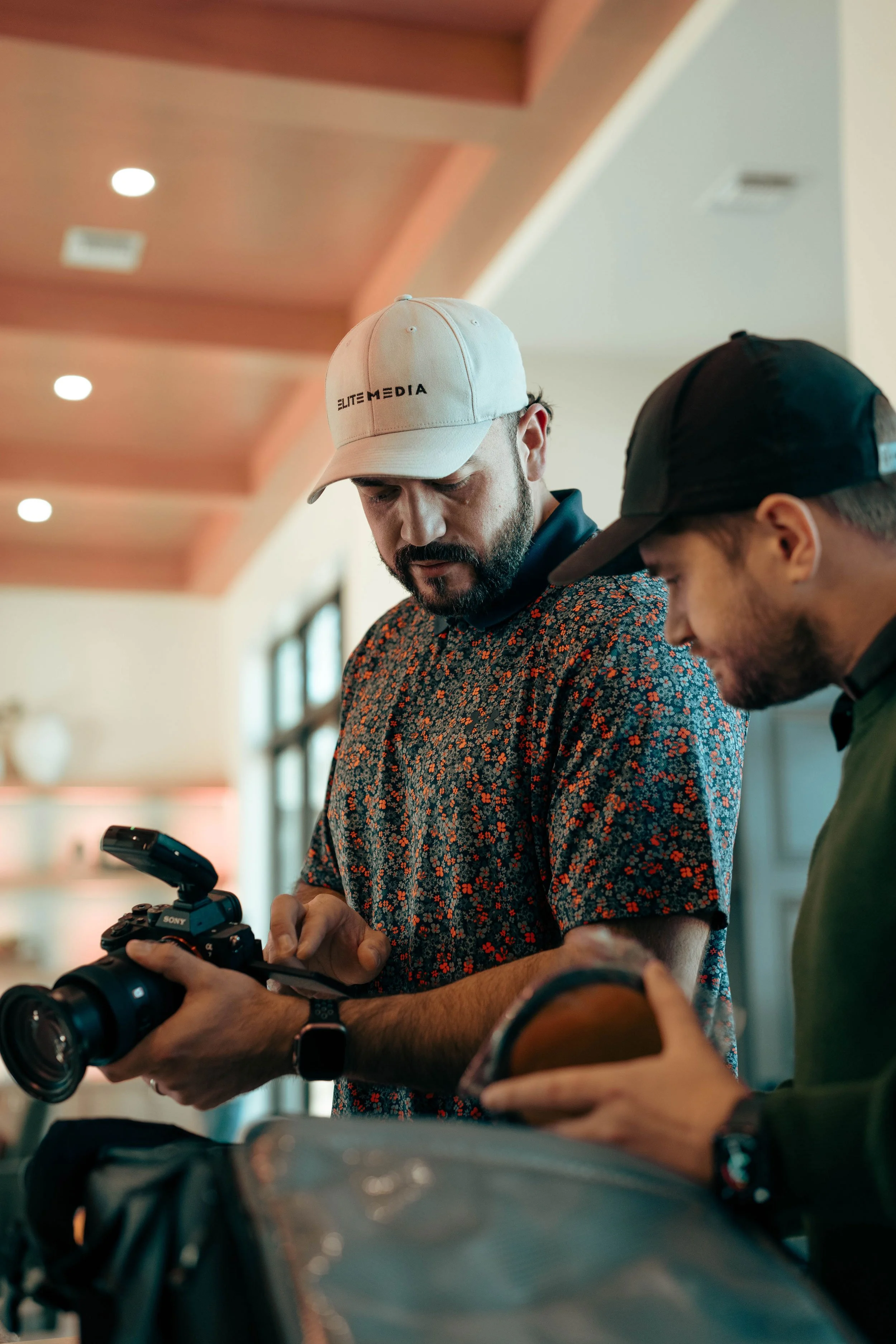 founder of elite media and staff member discussing settings on a camera during a shoot