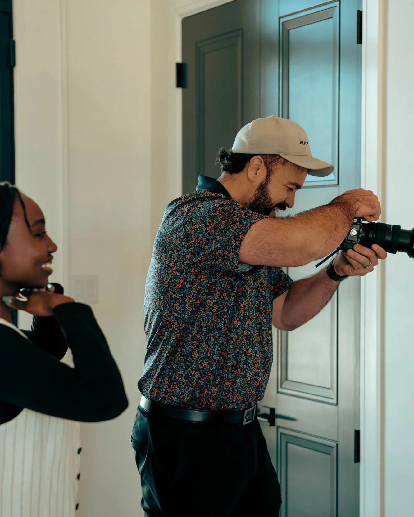 Elite Media founder taking photo of client while staff member coaches the pose off to the side