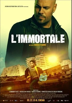 Cover of the movie poster for "L'Immortale" featuring a man with a serious expression and a woman holding items in an urban setting with damaged buildings and a bright sun.
