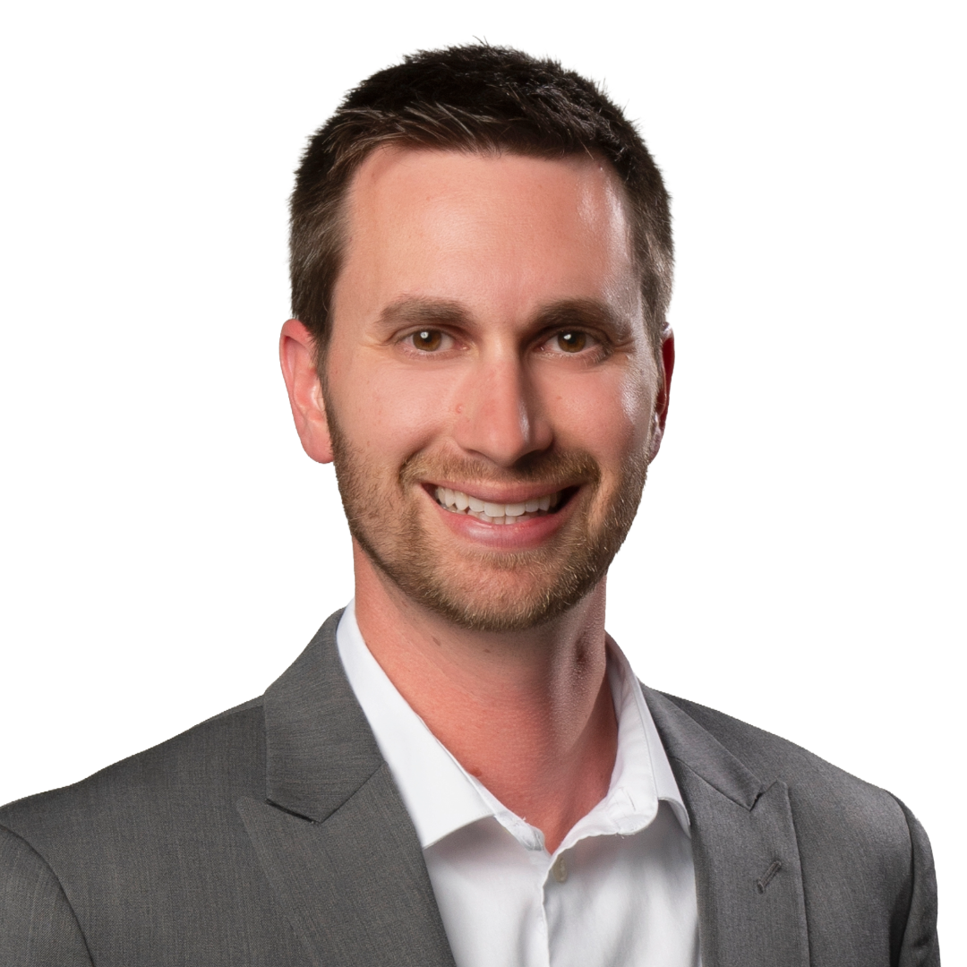 Professional headshot of a smiling man in a gray suit and white shirt against a white background.