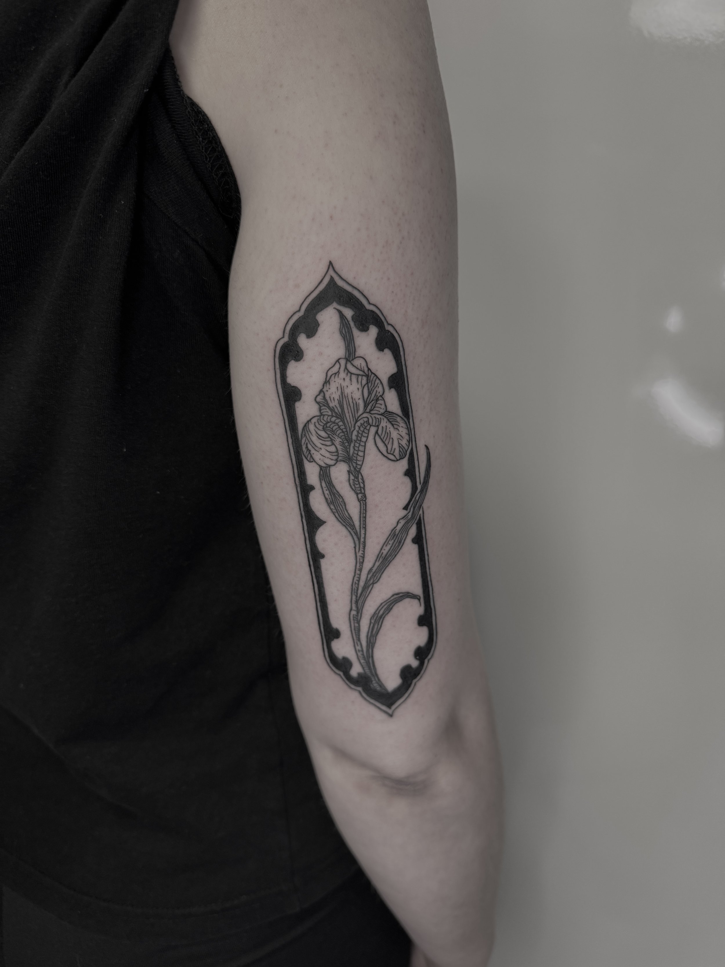 Schwarz-weiße Tattoovorlage eines Iris auf dem Oberarm