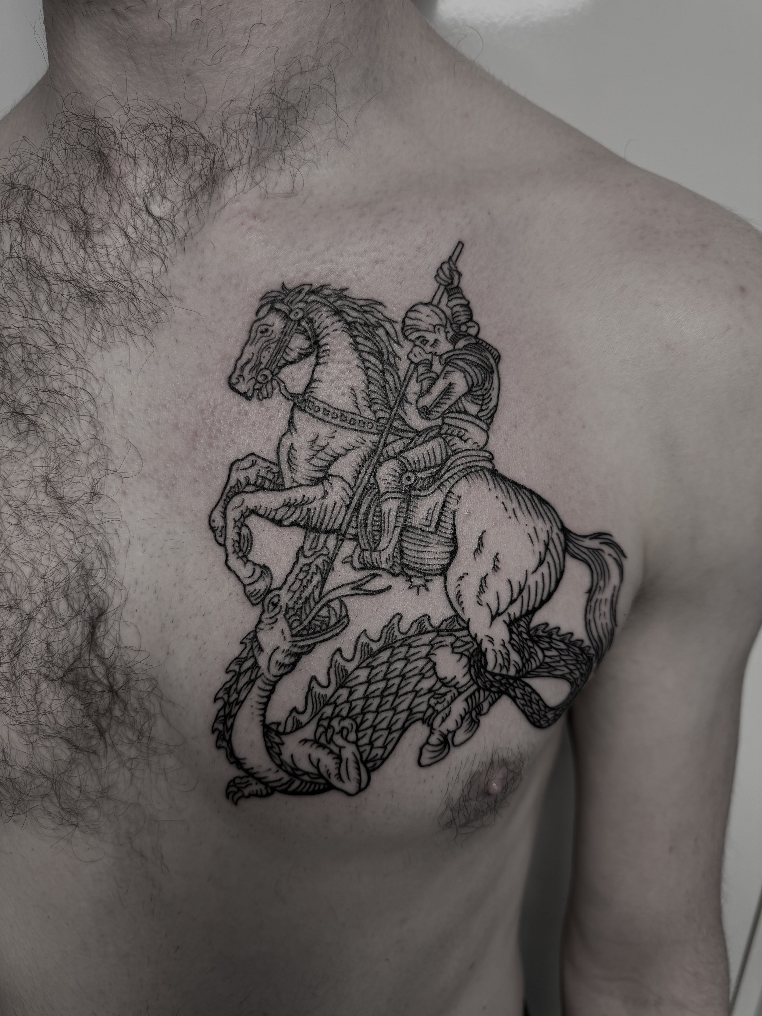 Tattoo eines Ritters auf einem Pferd, das einen Drachen bekämpft, auf der Brust einer Person.