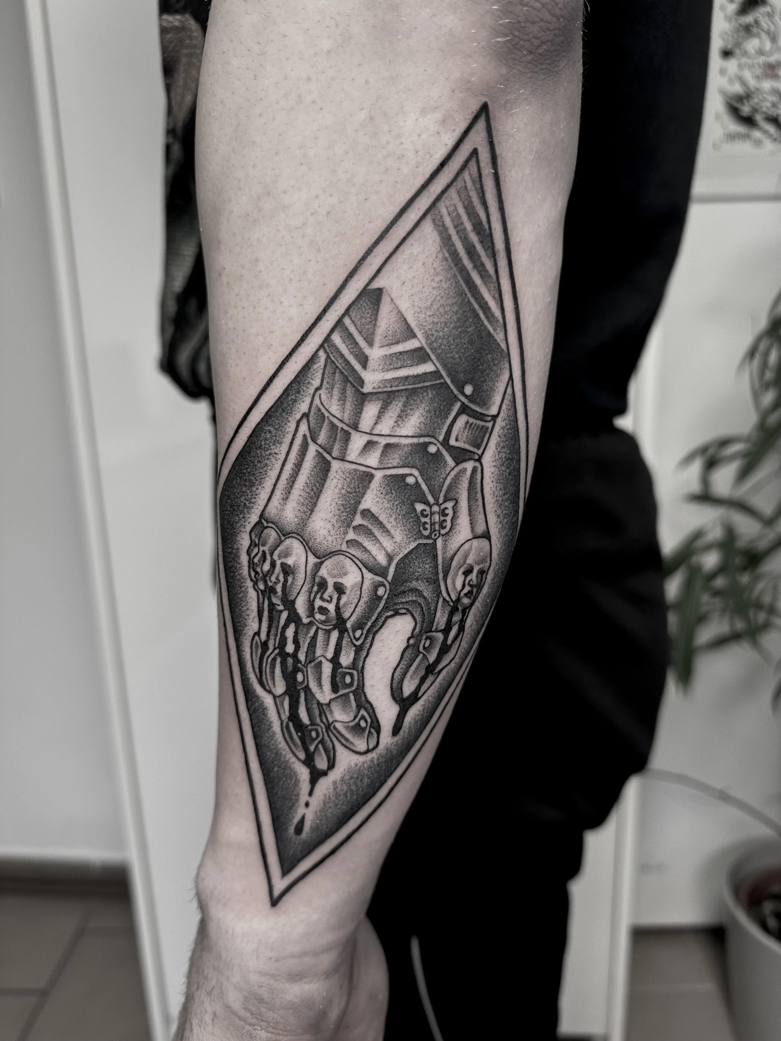 Schwarz-weiße Tattoo eines Roboters mit einer Hand, die auf einem weißen Hintergrund zeigt.