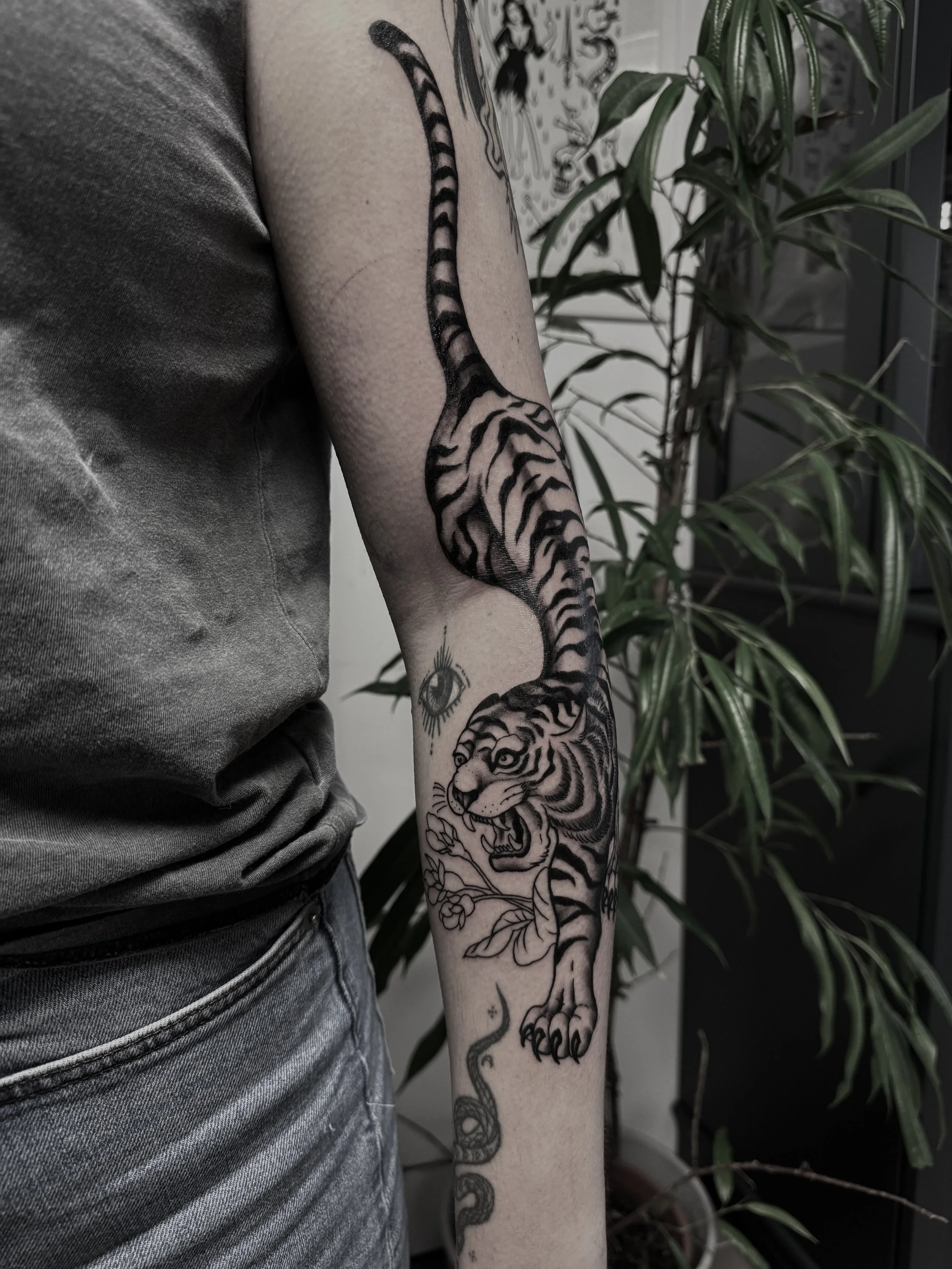Tattoo eines Tigers auf dem linken Unterarm einer Person.