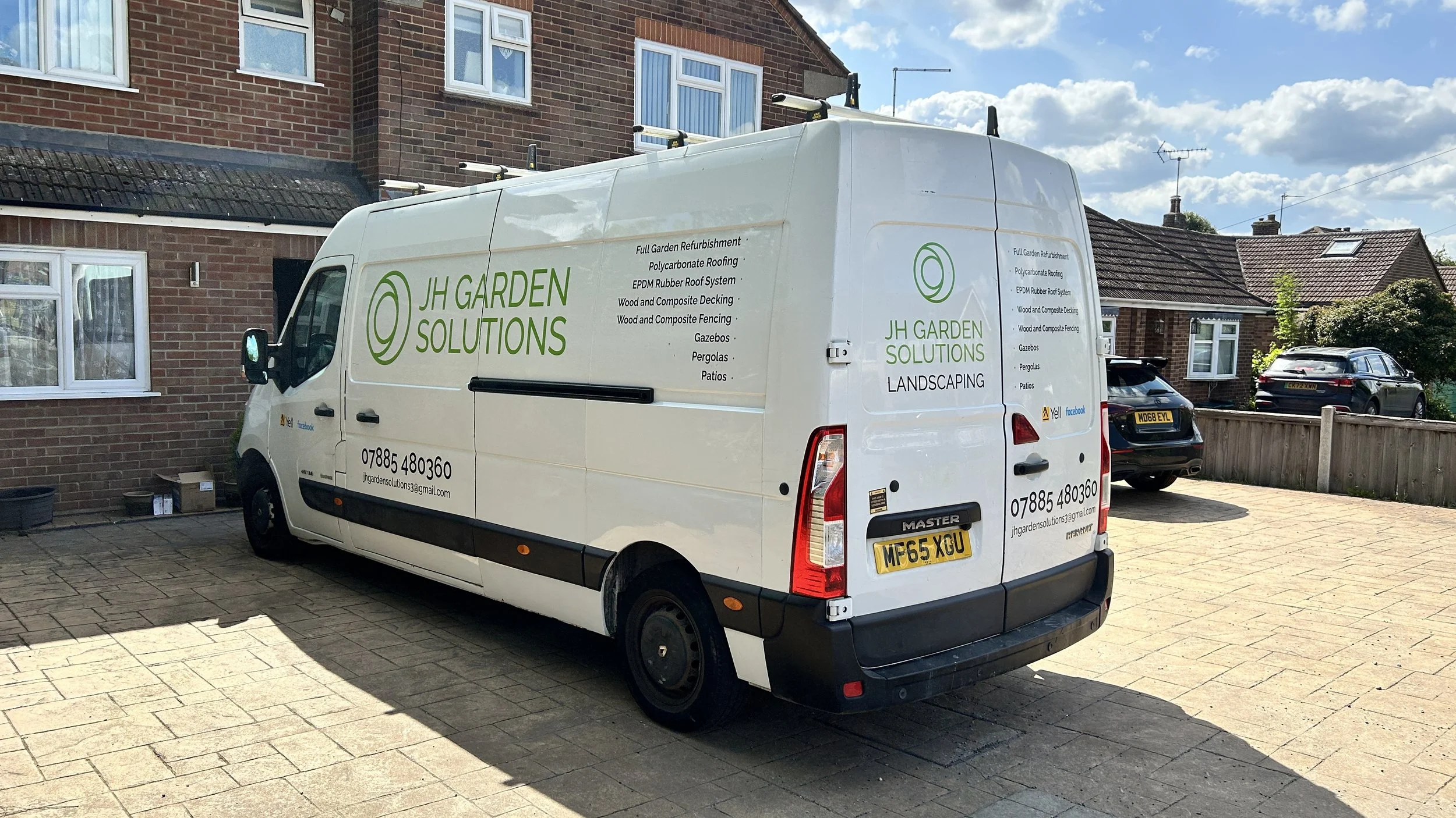 White van parked in a driveway with company branding for JH Garden Solutions, a landscaping business, on its side and back. The van advertises garden refurbishment, roofing, decking, fencing, and patios, with contact information and social media icon