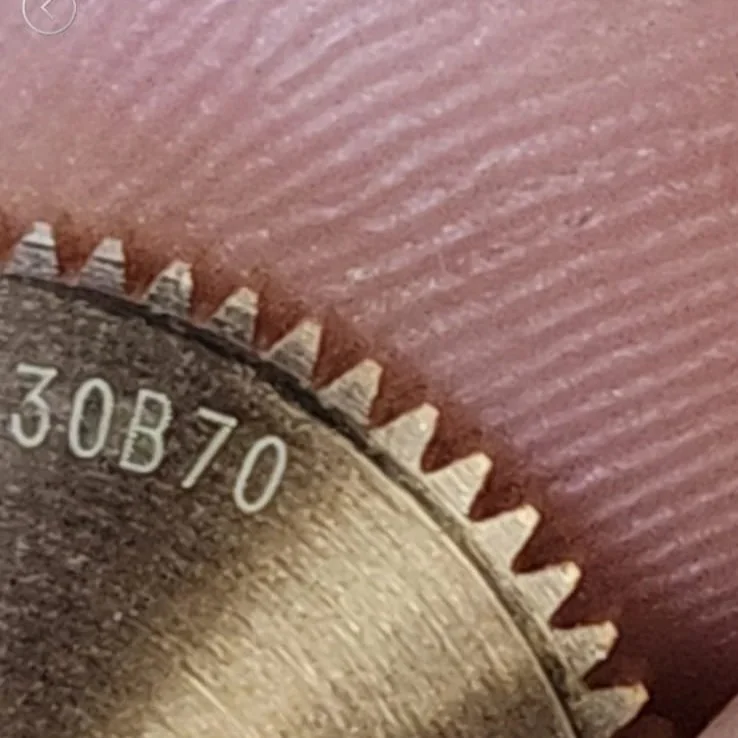 Close-up of a metallic gear with teeth, displaying the numbers 30B70.
