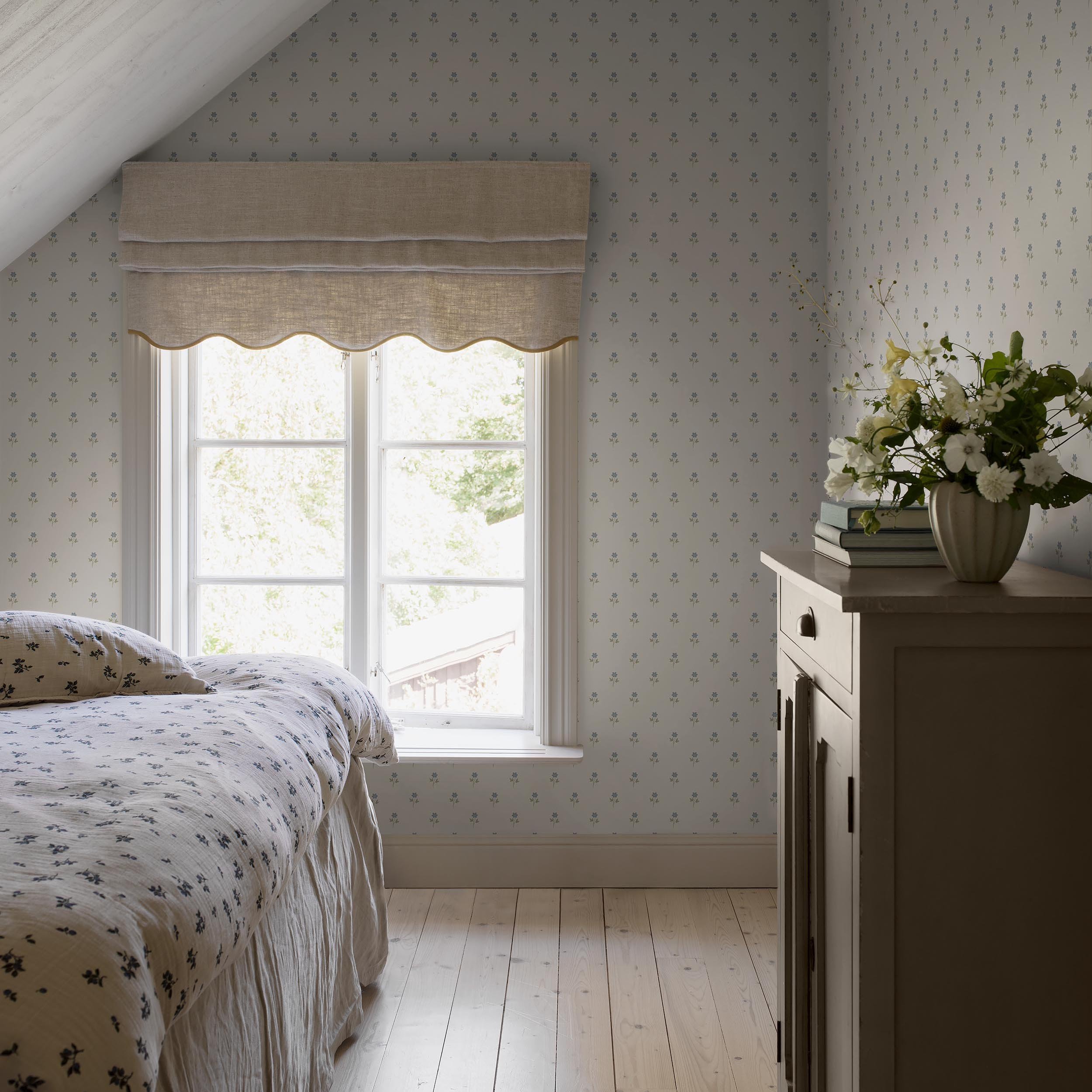 Attic bedroom with Schumacher Anemone wallpaper in Blue behind a Roman shade and dresser, showing pattern scale, SKU 6974