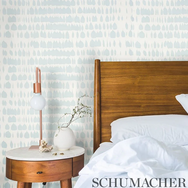 Schumacher Queen of Spain Sky wallpaper in a bedroom behind a wood headboard and marble nightstand