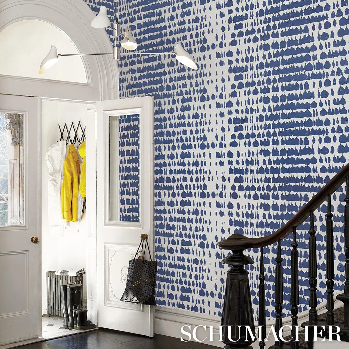 Schumacher Queen of Spain Navy wallpaper in an entry stair hall with a dark wood banister