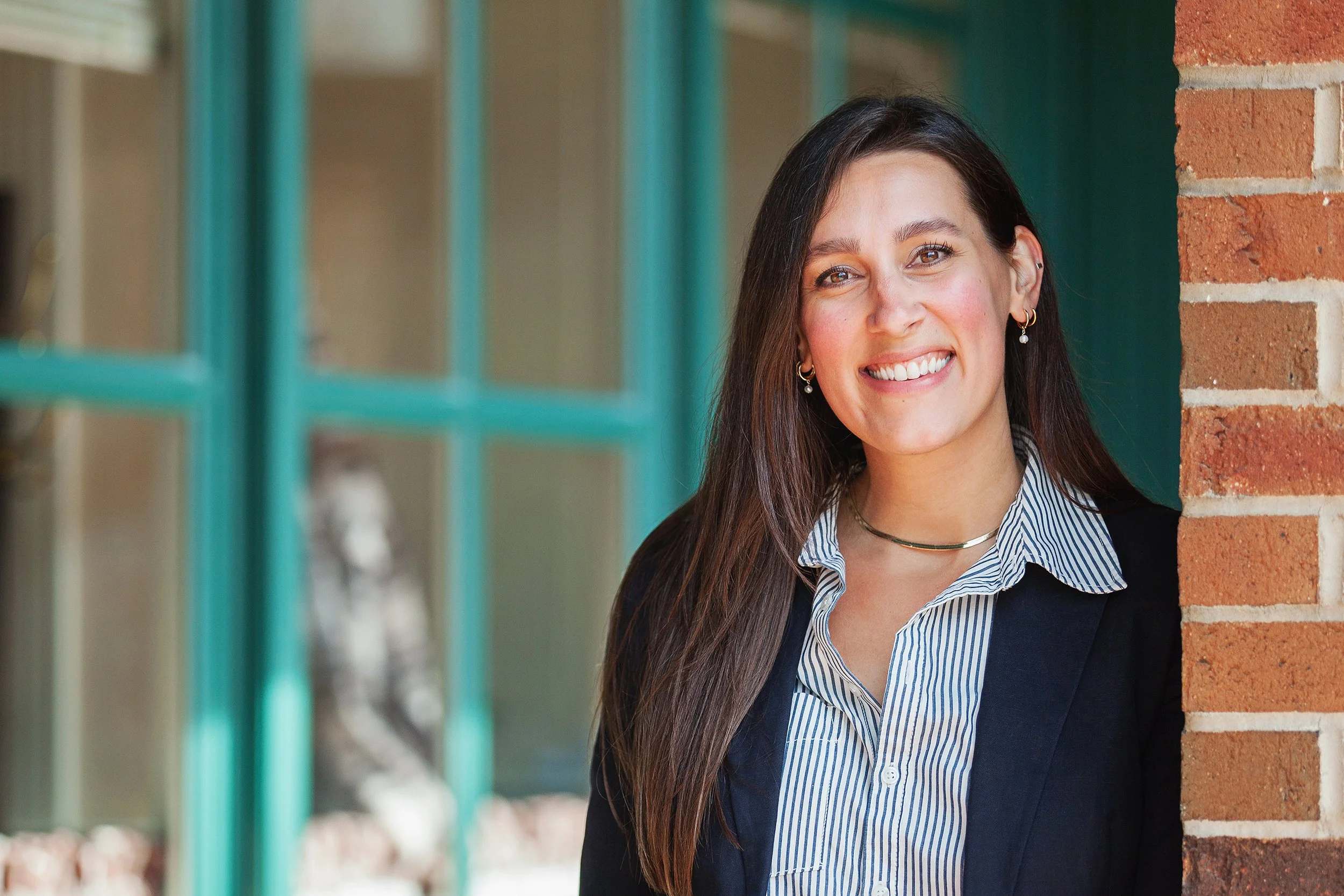Woman in blazer smiling during outdoor headshot session in downtown Kent Ohio
