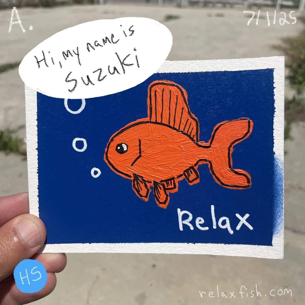 A colorful drawing of an orange fish wearing a watch, with the words 'Relax' written on it. The fish has a speech bubble saying, 'Hi, my name is Suzuki.' The background is blue, and the drawing is on a white piece of paper held by a person.