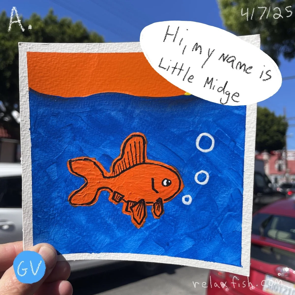 Handmade drawing of an orange fish with a collar, swimming in blue water with bubbles, on a sky background with trees. Text in a white speech bubble says, 'Hi, my name is Little Midge.' Hand holding the drawing with a blue sticker labeled 'GV'.