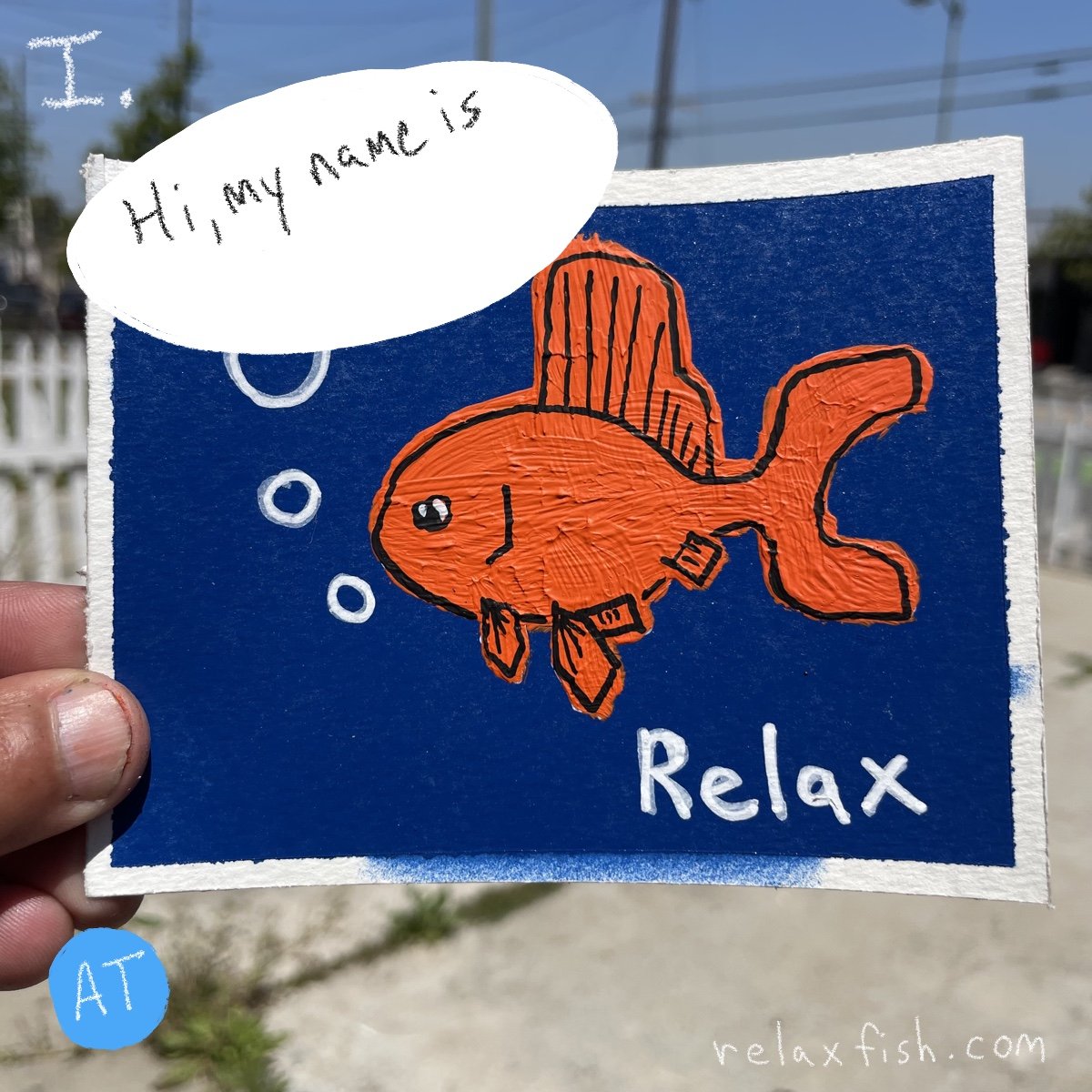 Drawing of an orange fish with black outlines on a blue background, with a speech bubble saying 'Hi, my name is' and the word 'Relax' written below. The website 'relaxfish.com' is at the bottom right.