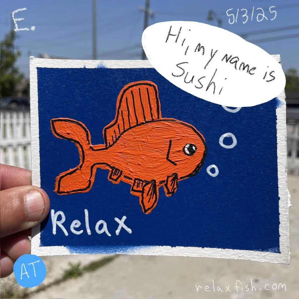 A hand holding a drawing of an orange fish with a black outline on a blue background. The fish is speaking and says, 'Hi, my name is Sushi.' The words 'Relax' and a blue circle with 'AT' are also visible, along with a website URL relaxfish.com.