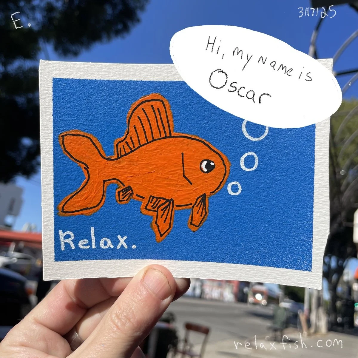 A colorful drawing of an orange fish with black outlines and fins on a blue background. The fish has a black eye with a white highlight. The word "Relax" is written in white at the bottom left, and a white speech bubble says, "Hi, my name is Oscar," 