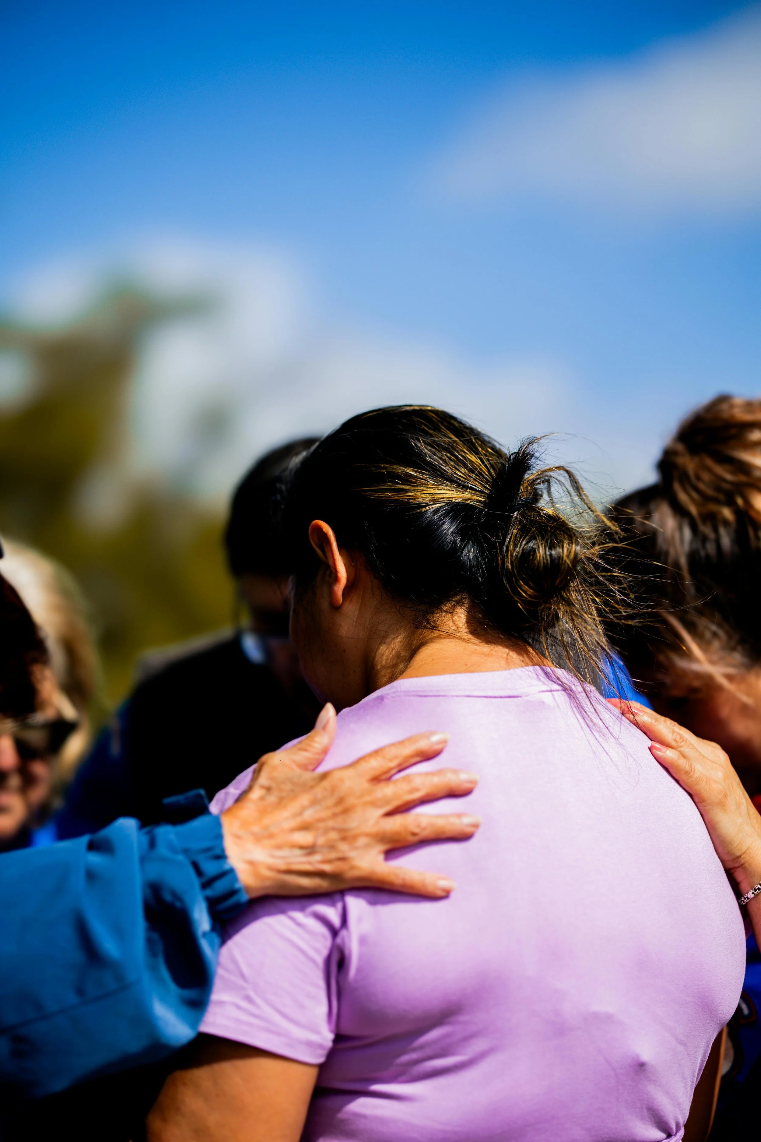 Image showing the back of a woman surrounded by people.