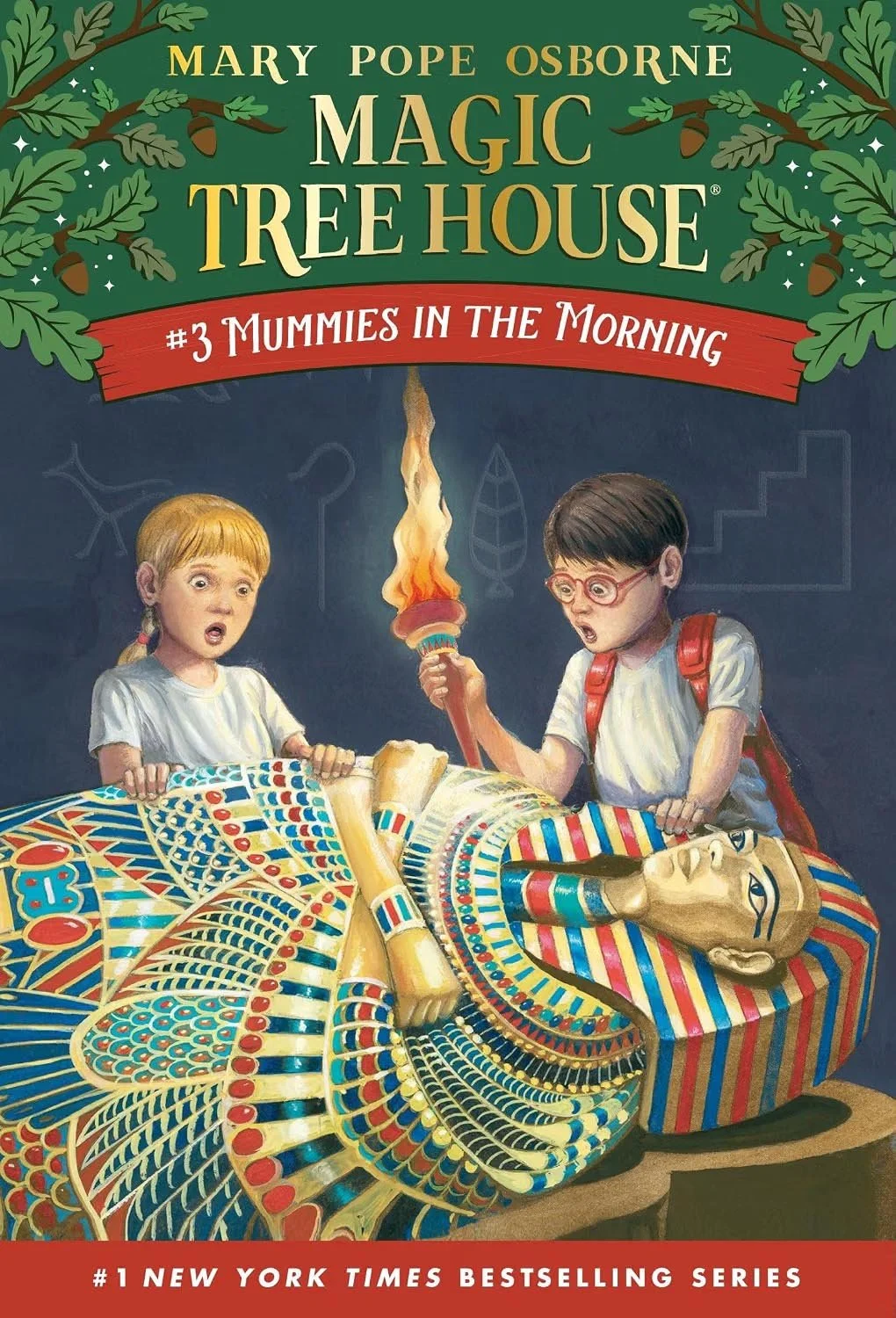 Book cover for "Magic Tree House #3 Mummies in the Morning" by Mary Pope Osborne. The illustration features two children, a boy and a girl, looking surprised and holding a flaming torch and a treasure chest with an Egyptian pharaoh's mask. The background is dark, with faint chalk drawings of stars, a question mark, and leaves.
