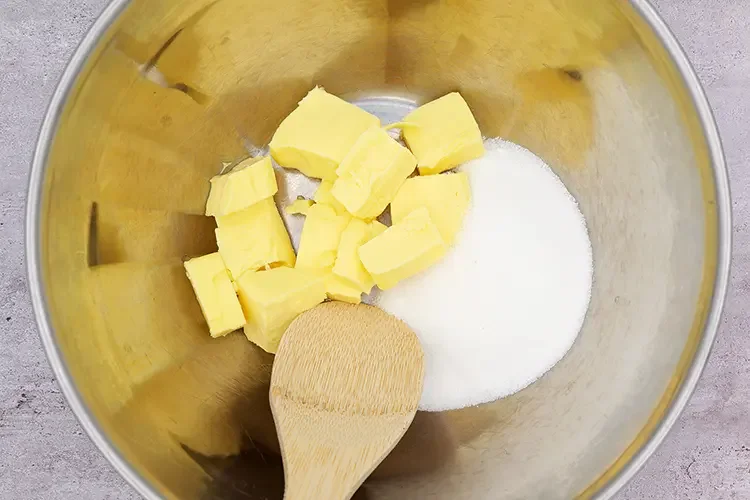 Butter cubes and sugar in a mixing bowl before creaming