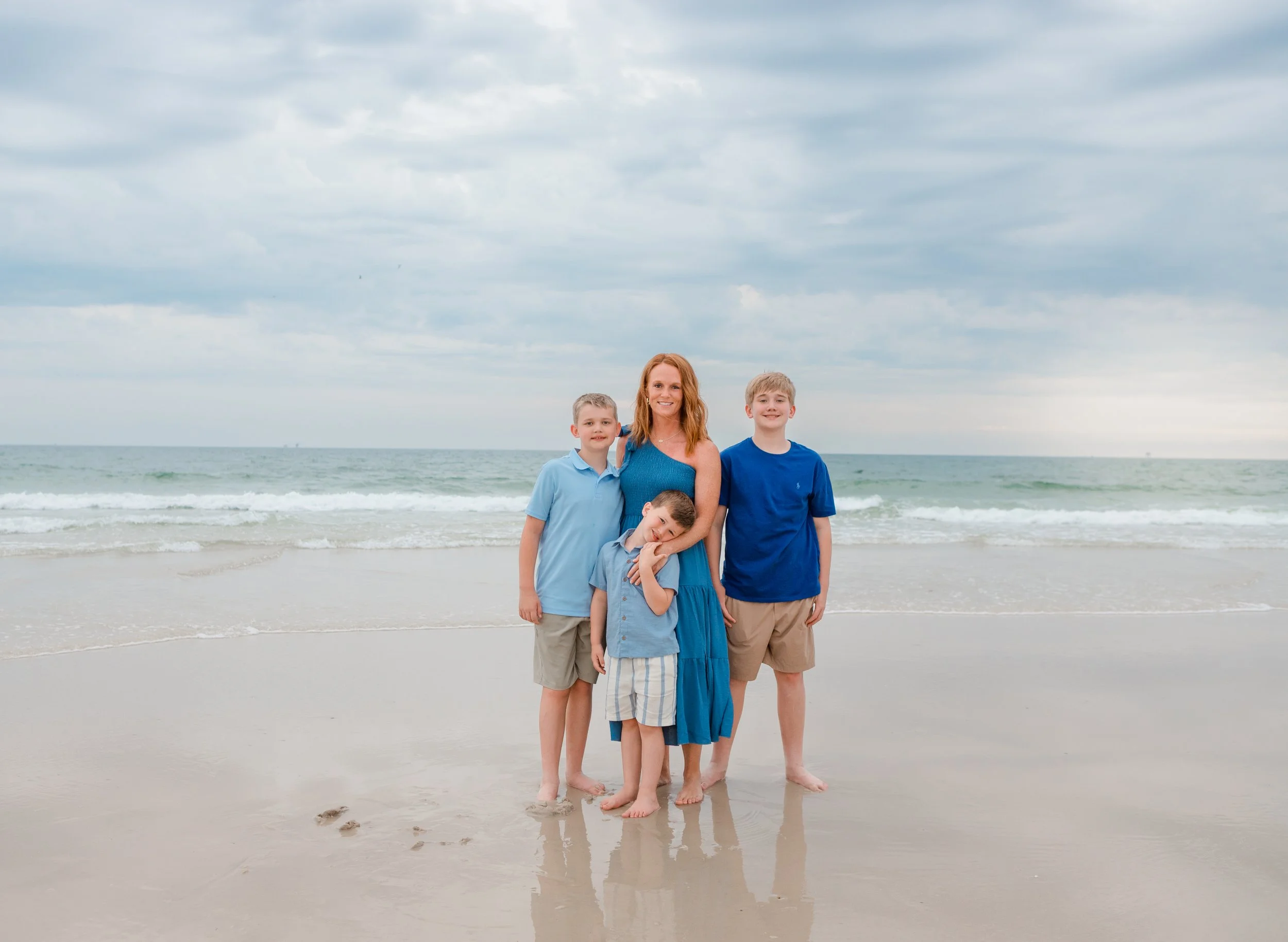 Mom with her 3 sons on the beach on the gulf coast waiting for sunset