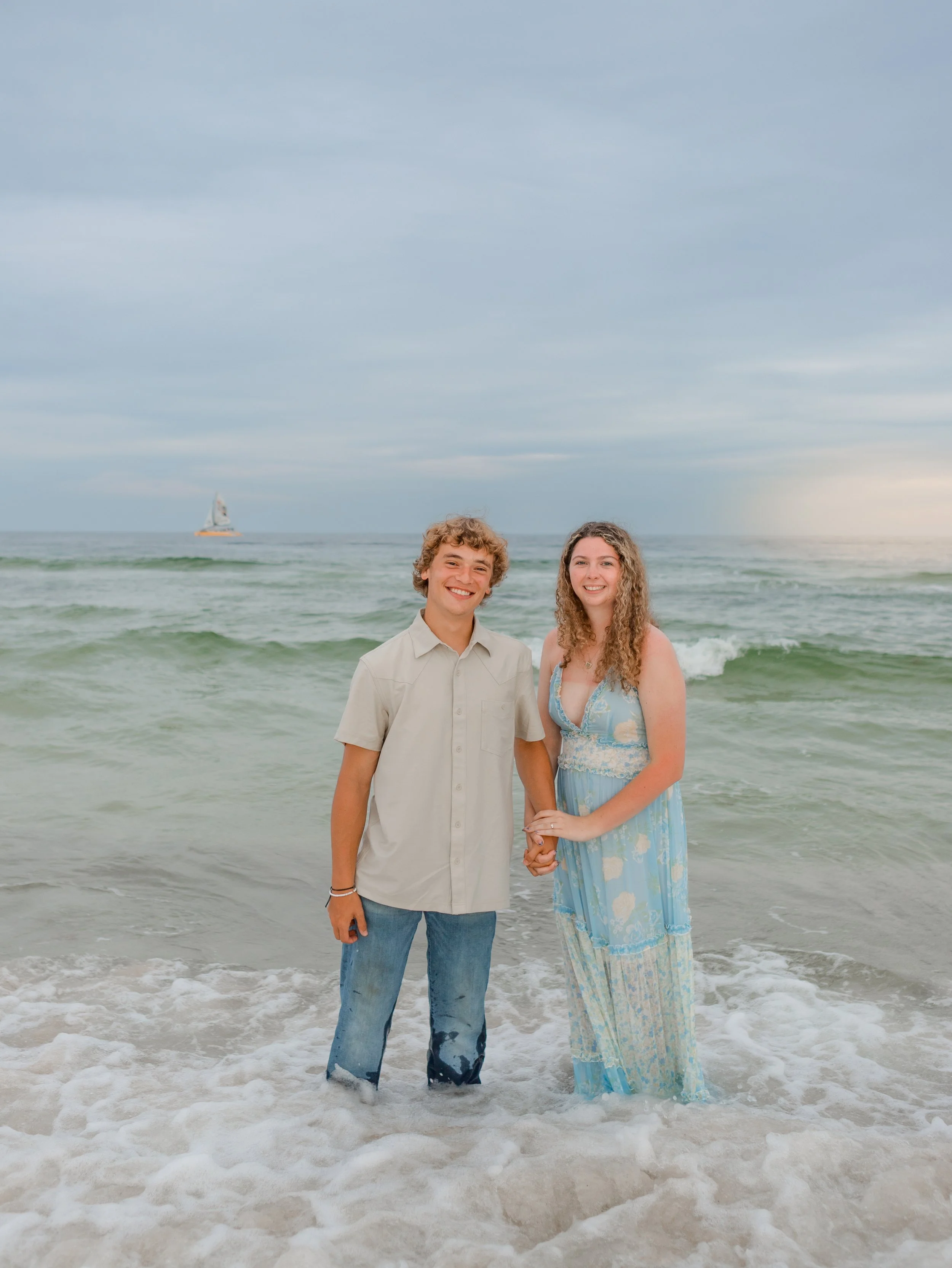 A young couple in Orange Beach, Alabama standing in the beautiful blue water for sunset. 