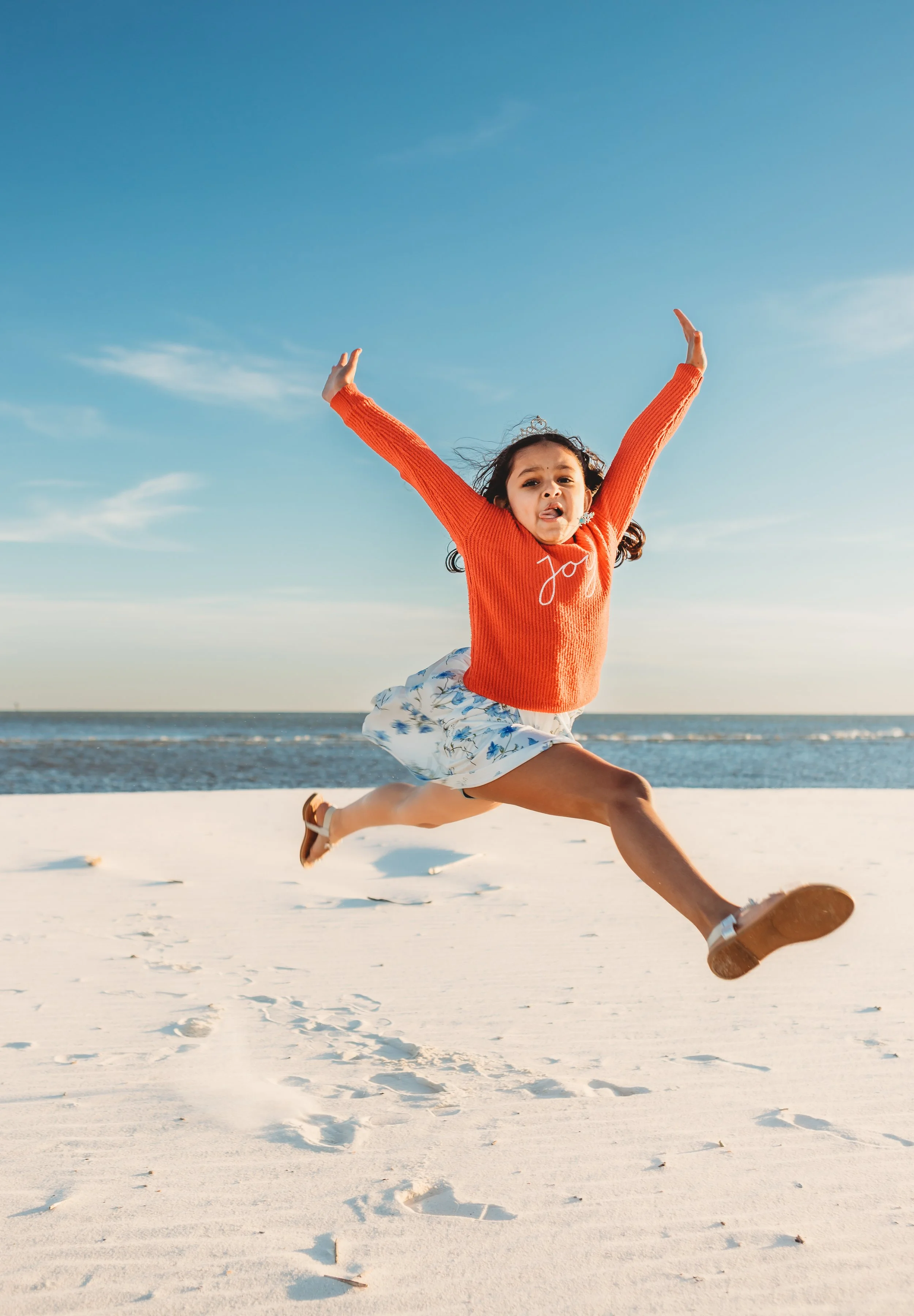 A little girl jumping in the air showing off her gymnastics skills in Orange Beach, Alabama

