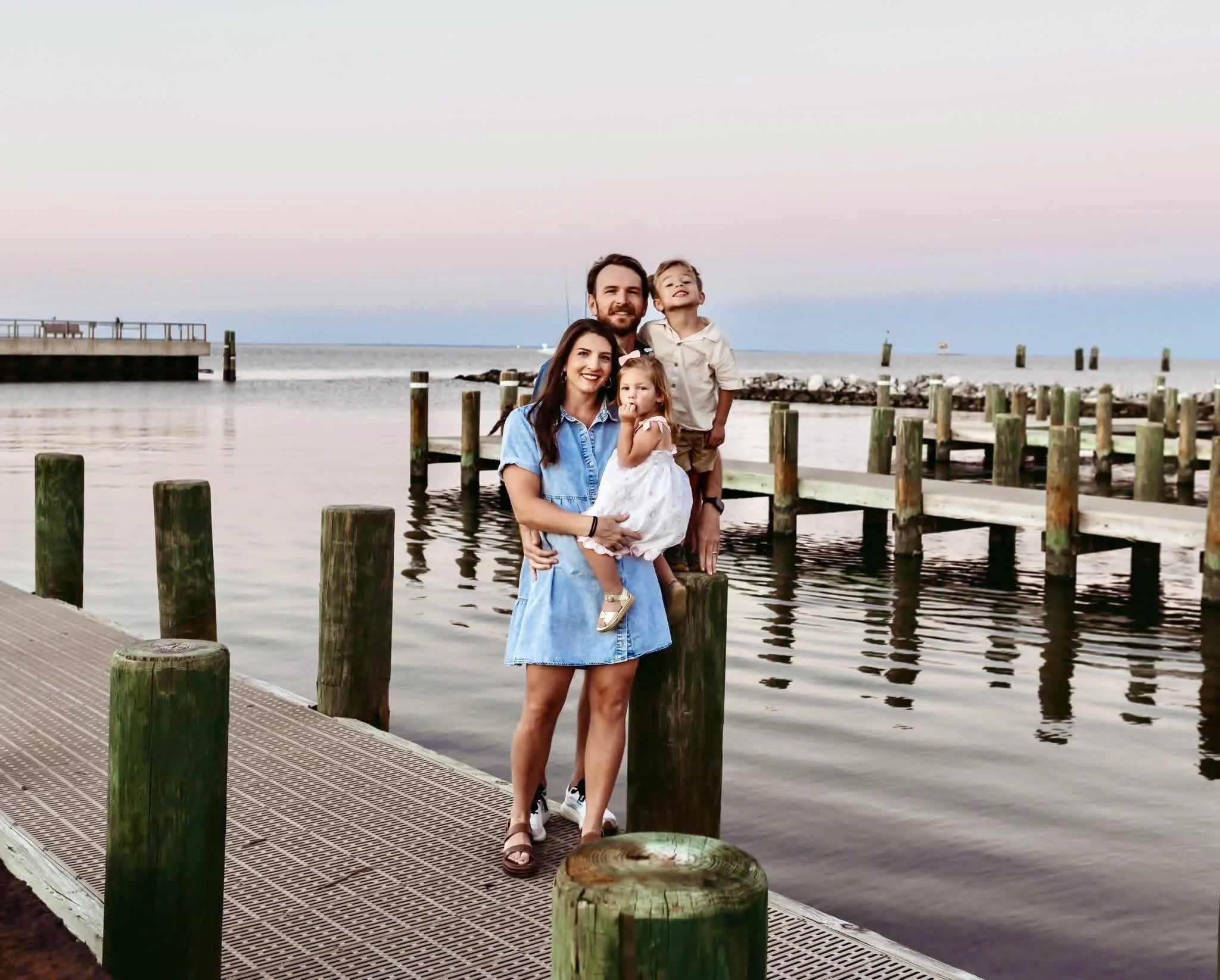 Young family standing on a pier during blue hour at Orange Beach, AL