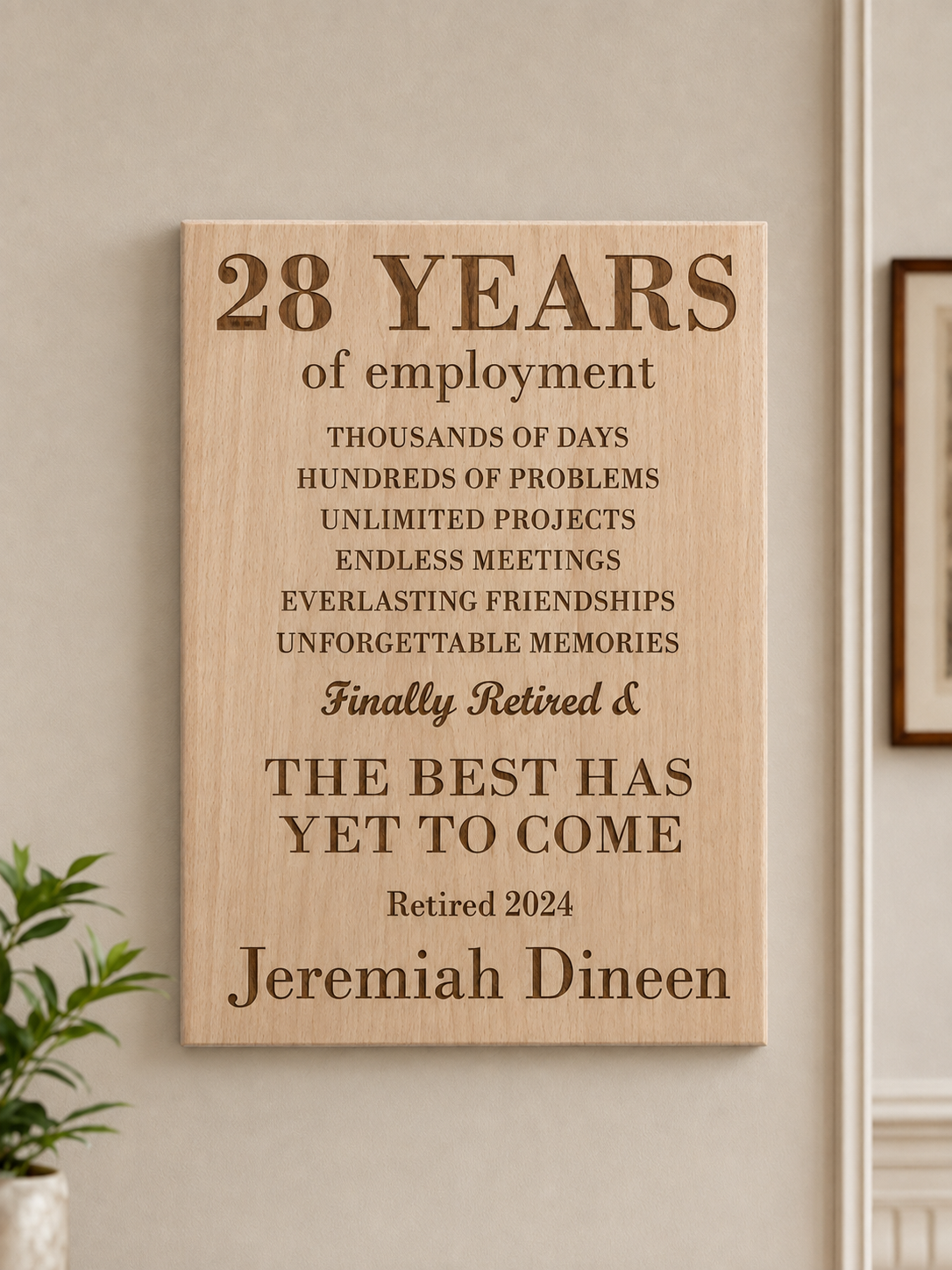 A wooden plaque commemorating 28 years of employment, featuring messages about work challenges and memories, and announcing retirement for Jeremiah Dineen in 2024.