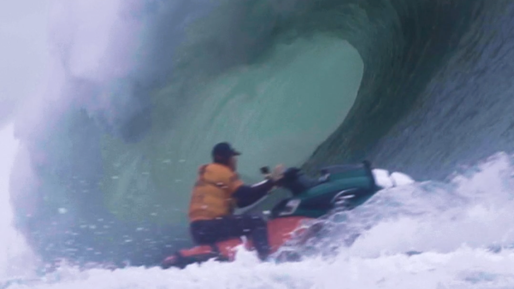 Person auf einem Jet Ski in einem großen Wasserwellenloch, umgeben von hohen Wellen.