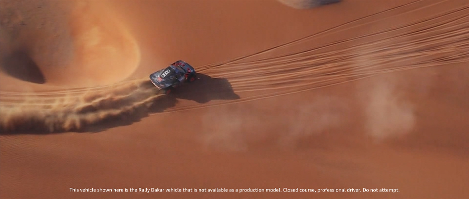 Ein Rennwagen bei der Dakar Rally, der auf Sand in der Wüste fährt.