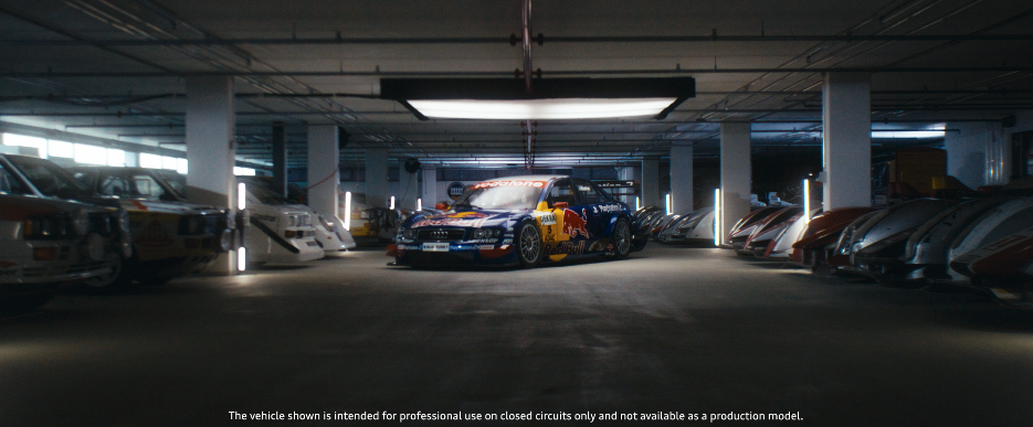 Ein Rennwagen in einer Tiefgarage, umgeben von klassisch alten Autos, mit gedämpfter Beleuchtung.