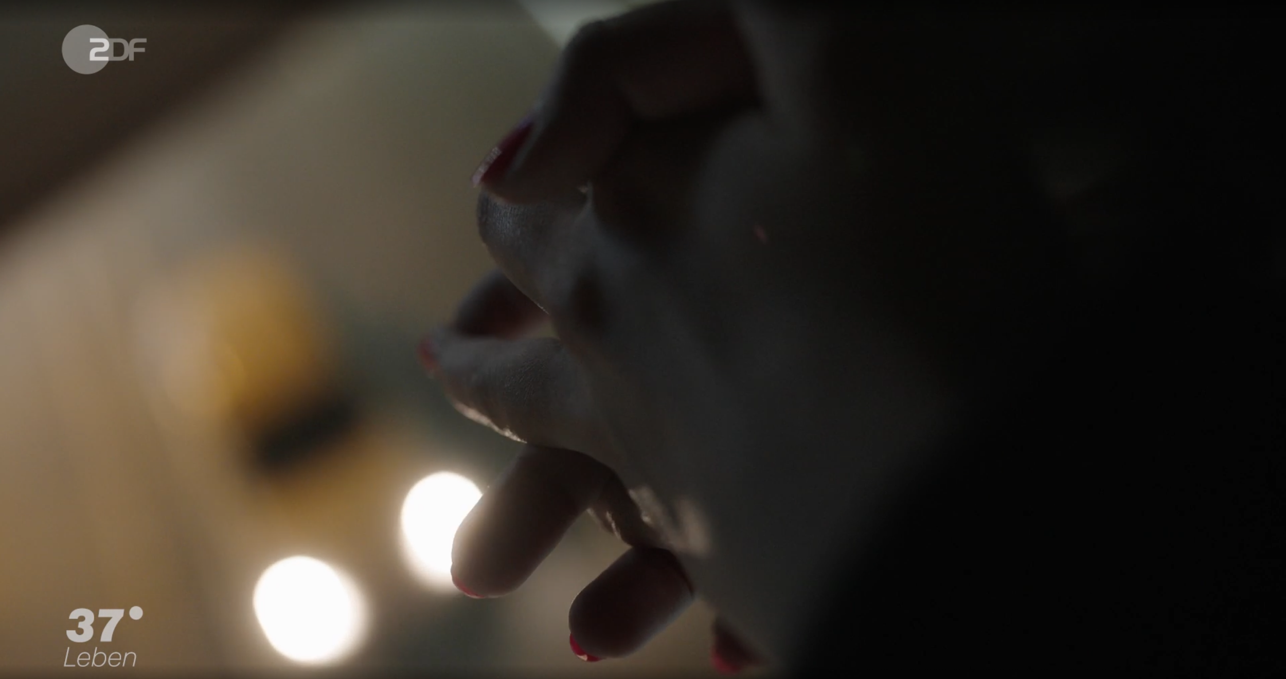 Nahaufnahme eines menschlichen Gesichts, das sich die Lippen leise berührt.