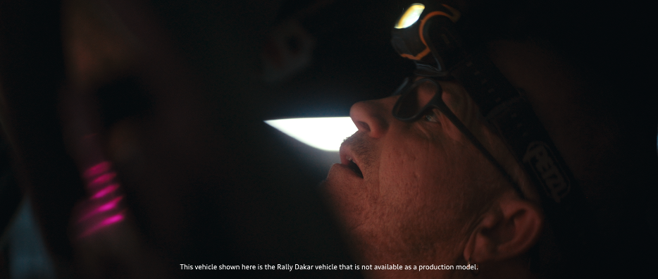 Ein Mann trägt eine Stirnlampe und schaut nach oben in einem dunklen Raum.