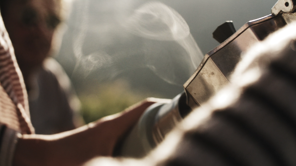 Nahaufnahme einer Person, die eine Holzsäge benutzt, mit Staub und Holzsplittern in der Luft.