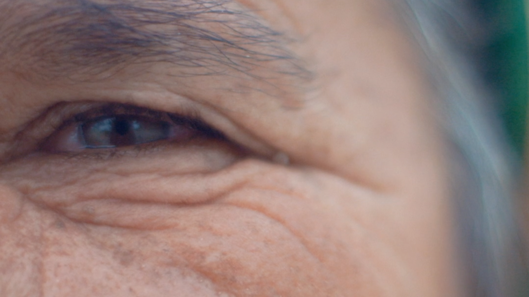 Nahaufnahme eines menschlichen Auges mit sichtbaren Falten und Hautstrukturen