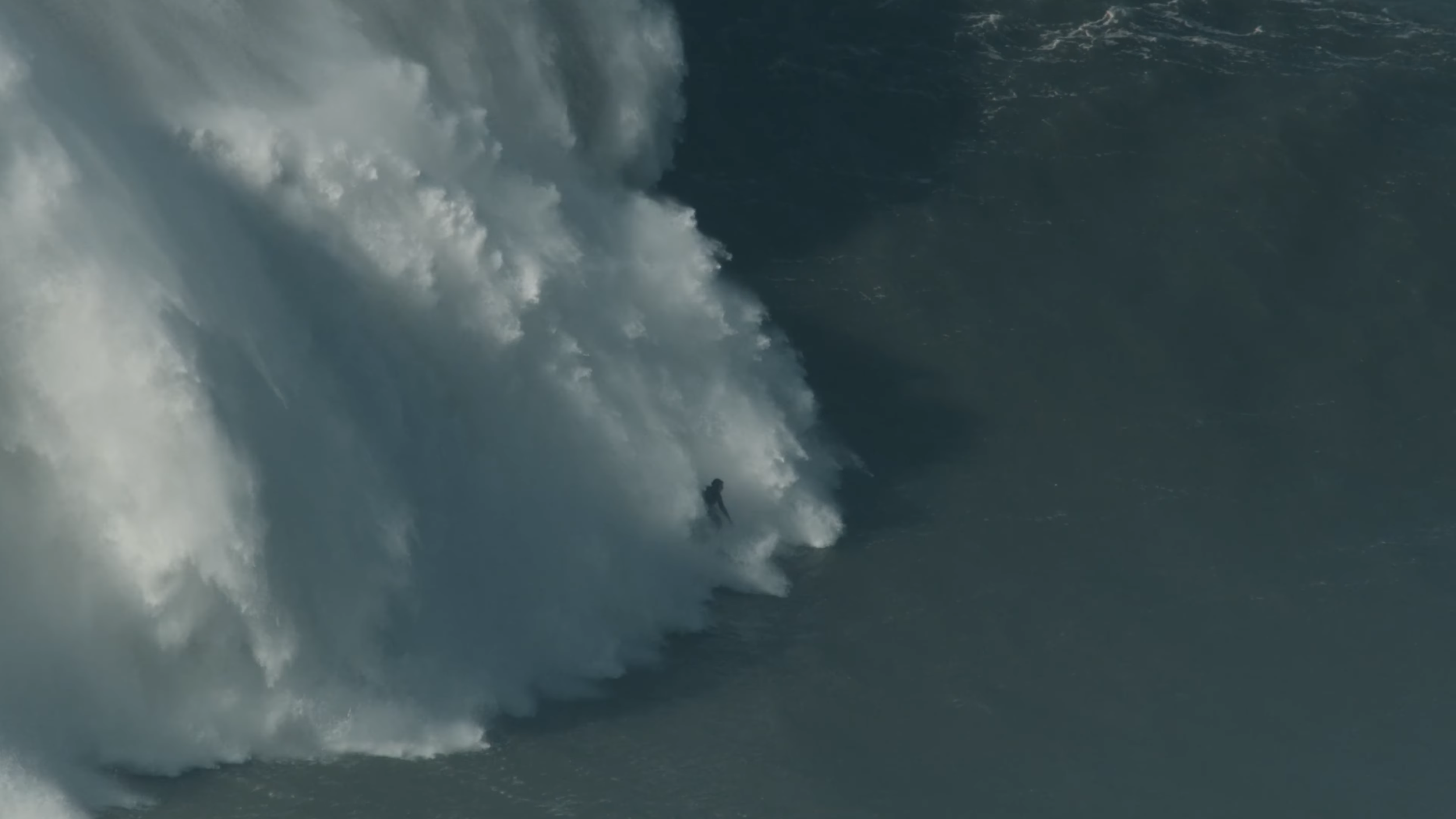 Ein Surfer fährt auf einer großen Welle im Meer.