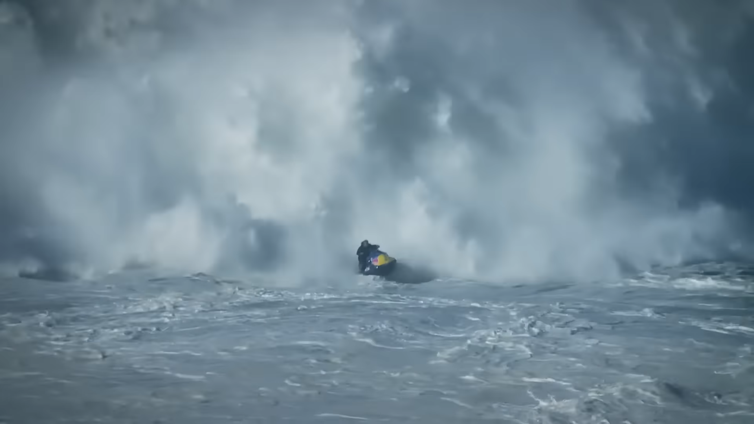 Ein Jet-Ski fährt durch raue, stürmische Meereswellen, wobei eine große Welle den Fahrer umgibt.