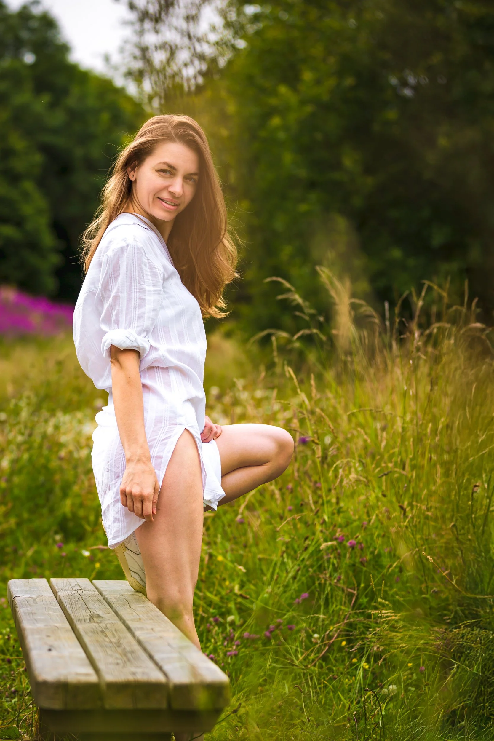 Sensual portrait of a woman wearing white summer dress in a park
