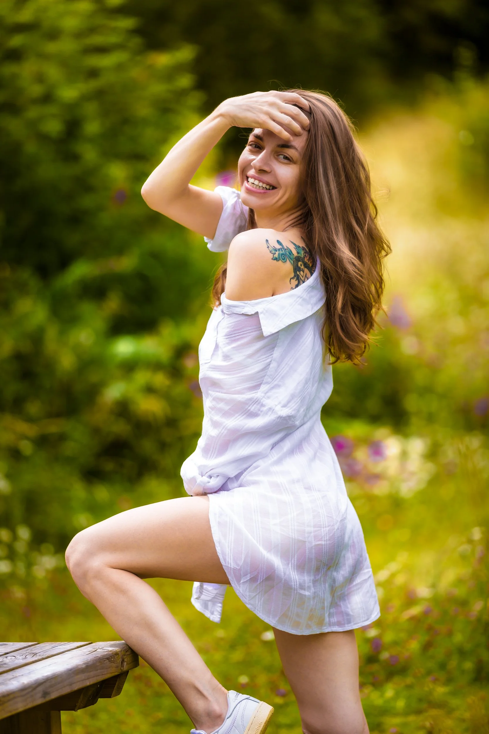 Sensual portrait of a woman wearing white summer dress in a park