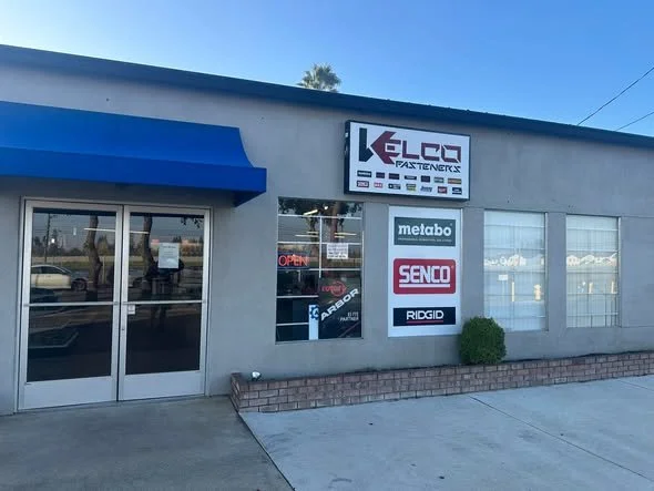 Front of a hardware store with signs for brands like Metabo, Senco, Rigid, and Karbon, and an
