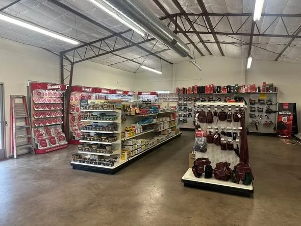 Industrial hardware store aisle with shelves of tools and accessories.